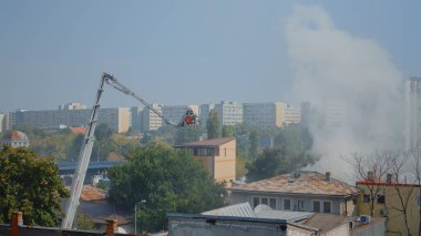 Platformdaki itfaiyeciler yangını söndürmek için çatıya çıkıyorlar.