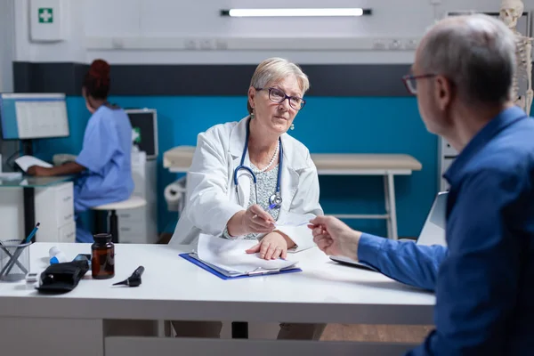 Facharzt gibt kranken Patienten Rezeptpapier mit Behandlung im Schrank — Stockfoto