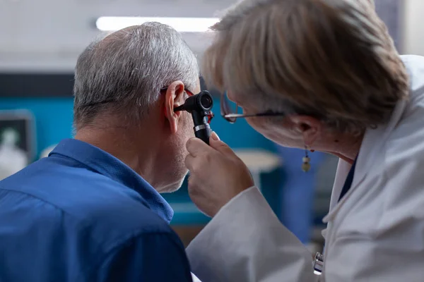女性医師保持耳を行うために聴診器で老人のために予約 — ストック写真
