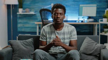 Afrikalı Amerikalı adam televizyonda futbol maçında tezahürat yapıyor.