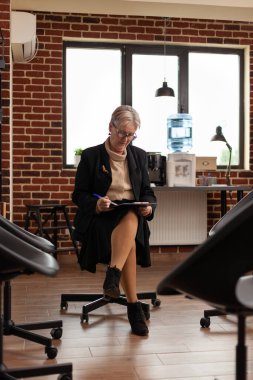 Elinde dosya olan psikoterapist toplantı için bekliyor.