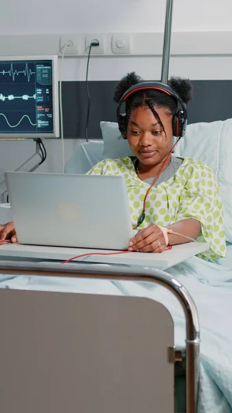 Patient malade utilisant un casque pour écouter de la musique — Photo