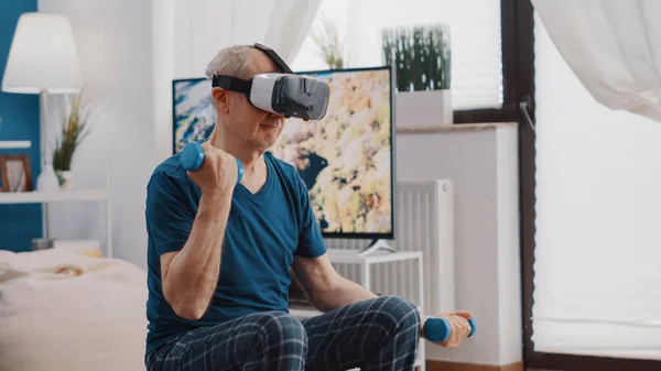 Captura de mão do homem mais velho treinando com halteres e usando óculos vr — Fotografia de Stock