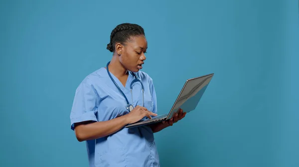 Retrato de enfermeira médica de uniforme olhando para a exibição do laptop — Fotografia de Stock