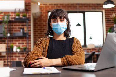 Coronavirüs enfeksiyonunu önlemek için tıbbi maske takan bir iş kadını portresi.