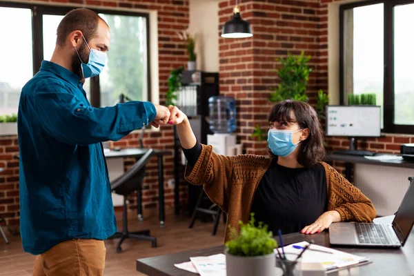 Бизнесмен в медицинской маске против covid19 приветственный менеджер женщина дает первый удар — стоковое фото