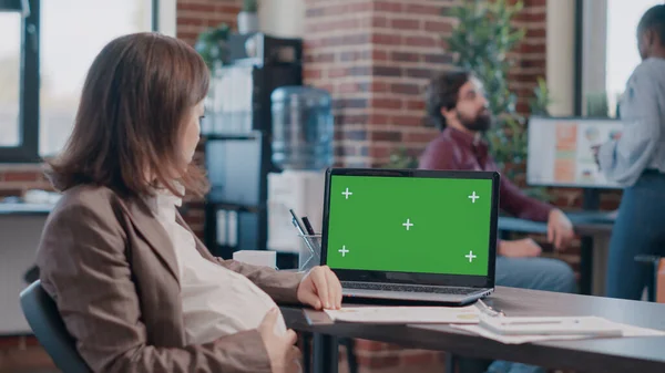 Adulte attend bébé et de travailler avec écran vert sur ordinateur portable — Photo