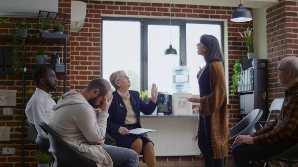 Angry woman explaining anger management problems at aa group meeting with psychiatrist