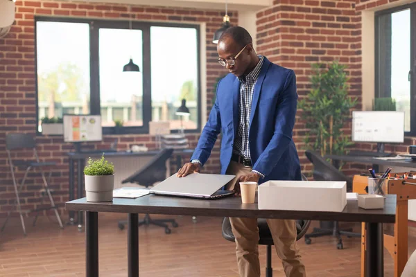 Afrikaans amerikaanse man verzamelen van bezittingen in doos na ontslagen uit het bedrijfsleven werkplek — Stockfoto