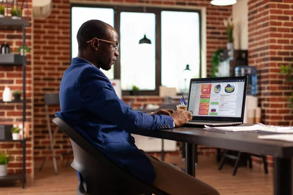 African american person using laptop to work on business charts and financial growth — Stock Photo, Image