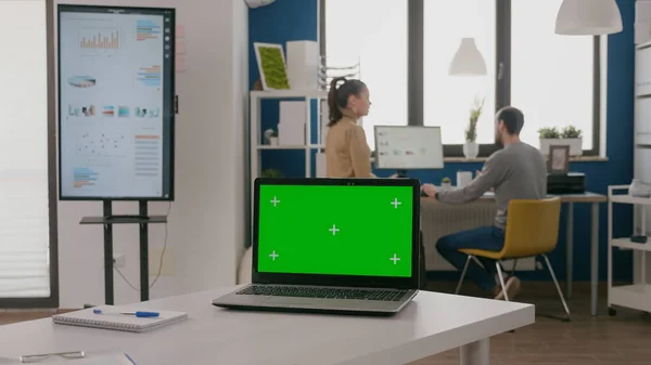 Sluiten van laptop met groen scherm aan leeg bureau — Stockfoto