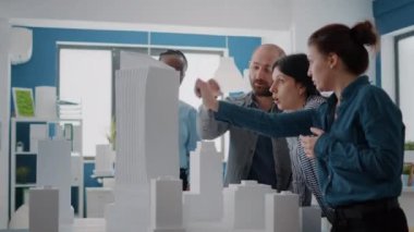 İnşaat planı ve planlarını planlamak için yapı modelini analiz eden mimarlardan oluşan bir ekip.