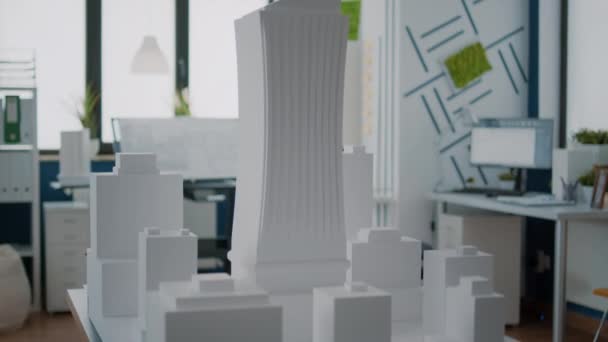Крупный план модели здания и городской структуры на столе в пустом офисе — стоковое видео