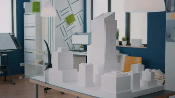 Conceito de modelo de edifício e projeto de construção na mesa em local de trabalho vazio — Vídeo de Stock