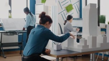 Kadın ve erkek, şehir projesinin planları ve modelleri ile birlikte çalışıyor.