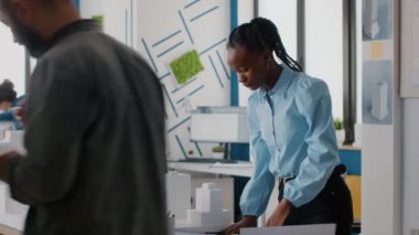 Afrika kökenli Amerikalı kadın mimari üzerinde çalışmak için plan ve model oluşturma analizi yapıyor.