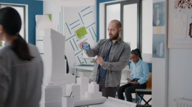 Endüstriyel mühendis inşa modeli ve akıllı telefon ile inşaat planı tasarlıyor