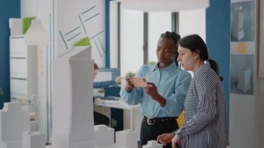 Endüstriyel inşaat yaratmak için cep telefonuyla bina modelini analiz eden kadınlar
