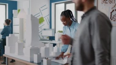 Bina modelini ve inşaat düzenini tasarlamak için plan hazırlayan kadın
