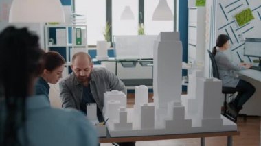 İş arkadaşları bina modelini analiz ettikten sonra plan tasarımı için takım çalışması yapıyorlar