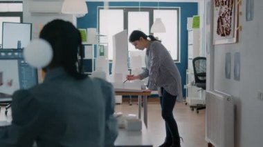 Kadın mimar, masa üzerinde model ve maketle planlar tasarlıyor.