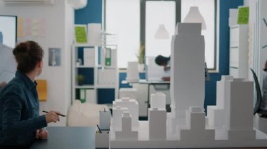 Erkek ve kadın birlikte çalışarak planlar tasarlıyor, model oluşturmaya çalışıyorlar.