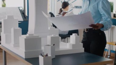Planları analiz eden ve geliştirme için model oluşturan kadın mühendisi kapat