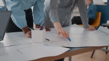 Masadaki planları analiz eden mimarları kapat.