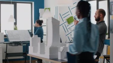 Yapı modelinin yapısını planlamak için tabletle çalışan adam mimar
