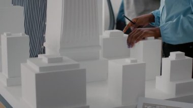 Model oluşturma, geliştirme için maketi analiz etme hakkında konuşan iş arkadaşlarına yakın çekim