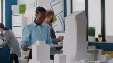 Bina planlarına bakan kadın mimarın portresi, yapım düzeni için ilham kaynağı bulmayı planlıyor