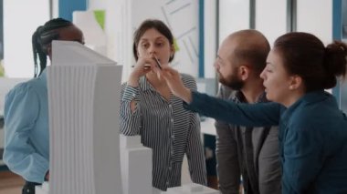 İnşaat yapısını tasarlamak için yapı modeli ile çalışan çeşitli insanları kapat