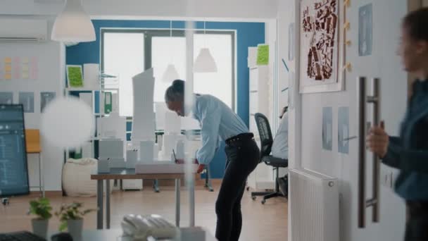 Arquitecta mujer trabajando en planos planean diseñar diseño de construcción con modelo de edificio — Vídeos de Stock