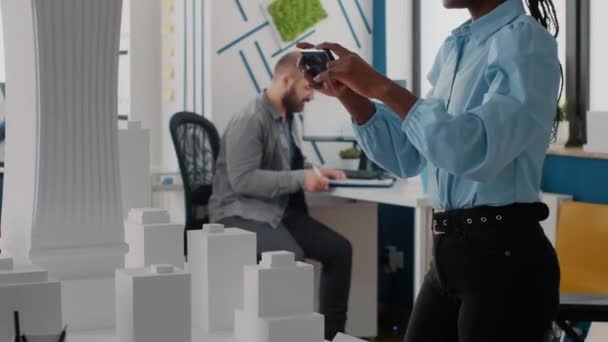 Detailní záběr ženy pracující s mobilním telefonem navrhnout model budovy a maquette. — Stock video