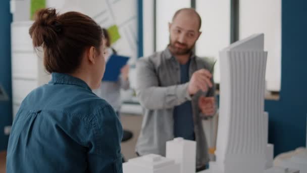 Ideas de lluvia de ideas de la mujer con el hombre para diseñar el plan de modelo de edificio y planos — Vídeo de stock