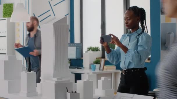 Ingeniera mujer usando smartphone para planear el diseño del modelo de edificio y maqueta — Vídeos de Stock