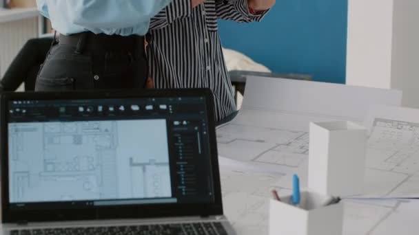 Närbild av kollegor som arbetar med ritningar och stadsbyggnad med surfplatta — Stockvideo