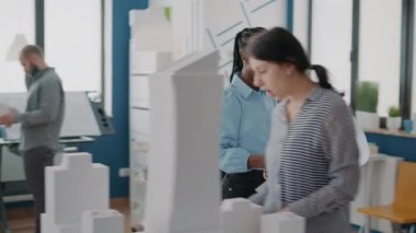 Çalışma arkadaşları planlarını ve masayı analiz ediyor, inşaat üzerinde çalışıyorlar.