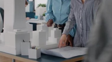 Masanın üzerinde plan tasarımı üzerinde çalışan çeşitli kadın takımlarını kapat