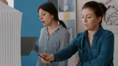 İnşaat tasarımı ve yapısını planlamak için bina modelini analiz eden kadın ve erkeklere yakın çekim