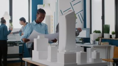 Afrika kökenli Amerikalı bir mimarın tasviri. Modellik üzerine çalışma planları üzerinde çalışıyor.