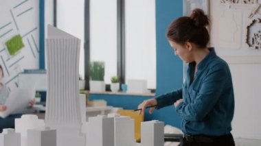 Proje için bina modelini tasarlamak için planlar, dizüstü bilgisayarlar ve tablet kullanan meslektaşları kapat