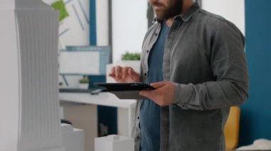 İşyerinde model ve maketi tasarlamak için tablet kullanan mühendisi kapat