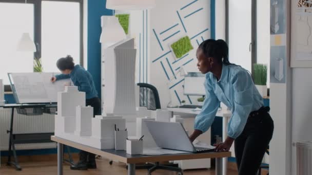 Afrikai amerikai nő használja laptop tervezésére épület modell és tervrajzok terv. — Stock videók