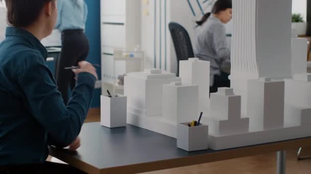 Közelkép a férfi és nő tervezése tervrajzok terv, elemzése épület modell — Stock videók