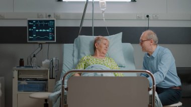 Anne ve çocuk hastane koğuşunda büyükannesine çiçek getiriyor.