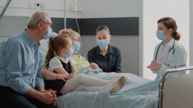 Hastane koğuşundaki insanlara teşhisi açıklayan doktor.