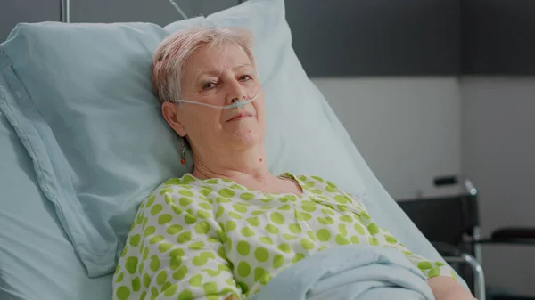 Sluiten van oudere vrouw zitten in ziekenhuis afdeling bed — Stockfoto