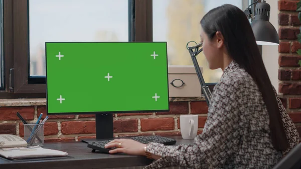 Business woman working with horizontal green screen on monitor — Stock Photo, Image