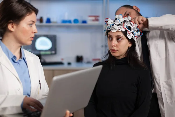 Médico neurólogo sosteniendo computadora portátil mostrando tomografía a paciente mujer — Foto de Stock